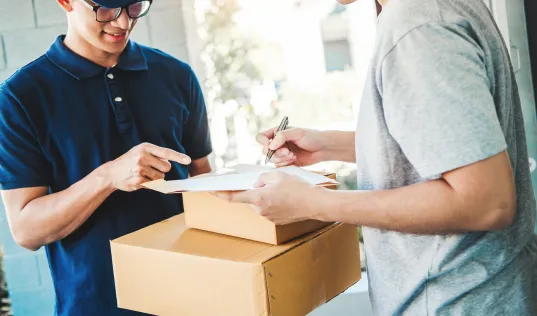 delivery worker handing a paper over to a client to sign